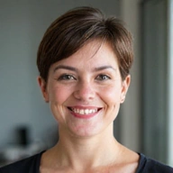 Photo de profil d'une femme souriante, professionnelle et amicale, avec des cheveux courts.