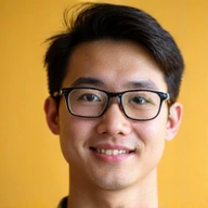 Photo de profil d'un jeune homme aux lunettes, souriant, professionnel et amical.